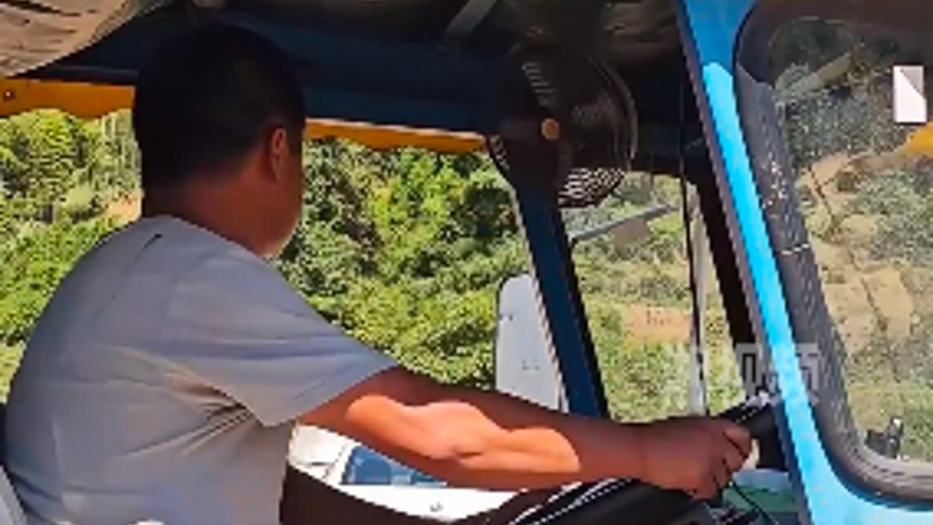 暴雨袭击后，湖南资兴男子开拖拉机驶过地基流失路面运送物资