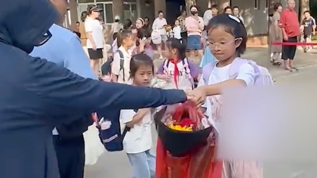 最好的报答是好好学习！老师站在校门口不让学生带礼物进校